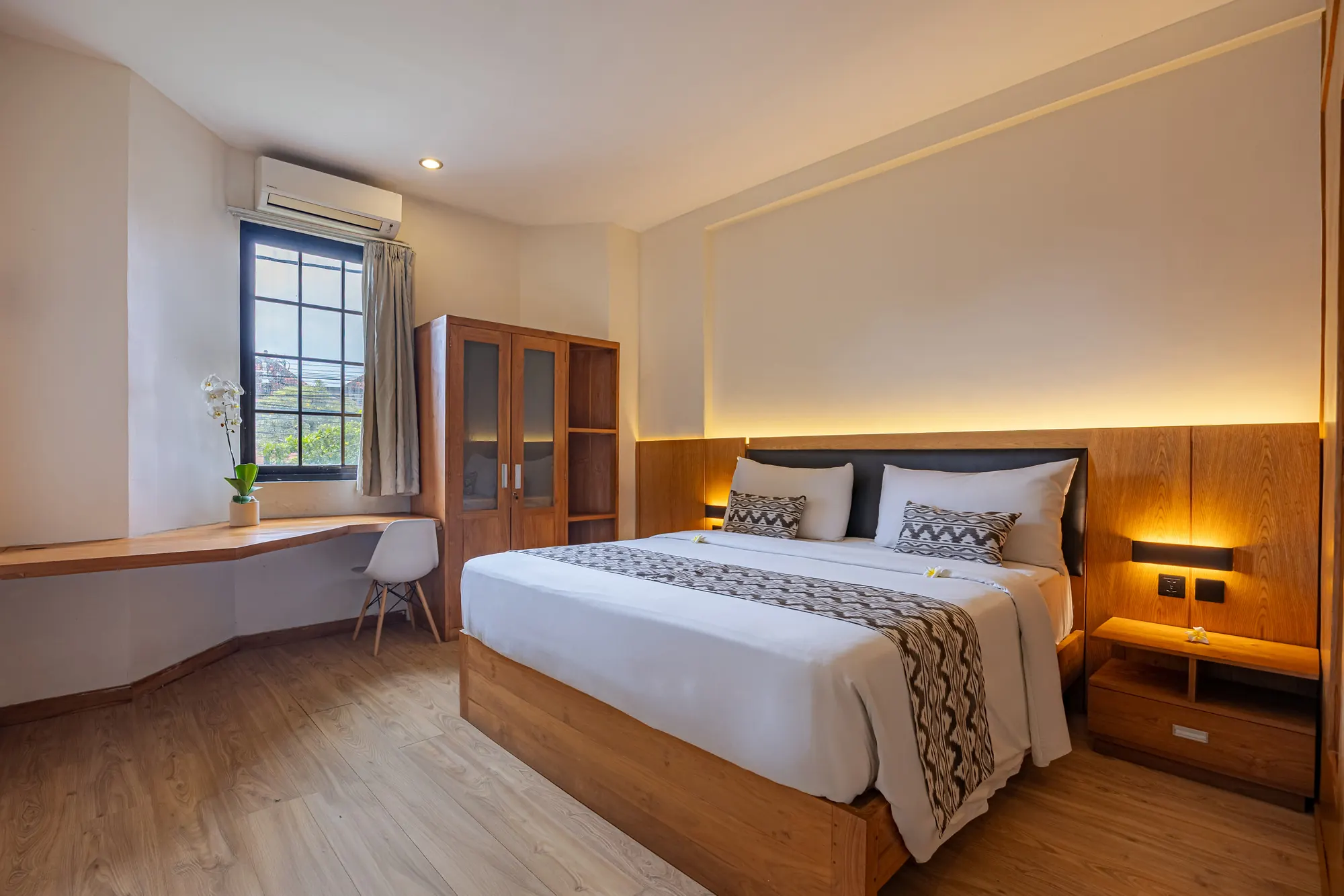 Signature Room apartment in Denpasar, Bali, with wood flooring and a desk in the bedroom